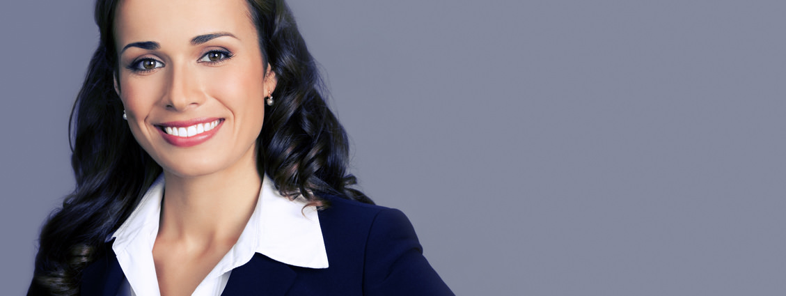 Portrait of cheerful smiling young businesswoman in black suit, with blank copyspace area for text or slogan, posing at studio, over violet background